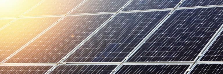 A close up of a solar panel with the sun shining on it.