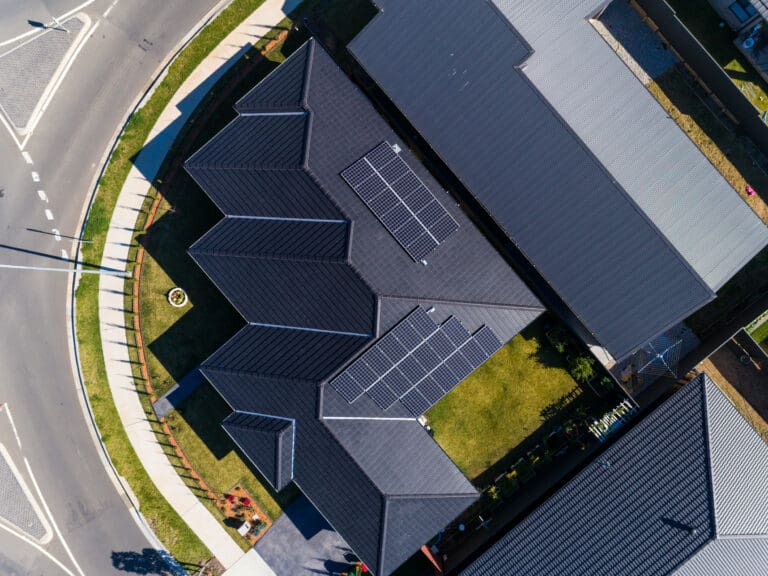 An aerial view of a house with solar panels on the roof.