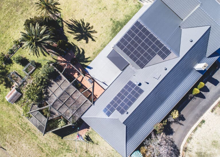 An aerial view of a house with solar panels on the roof.