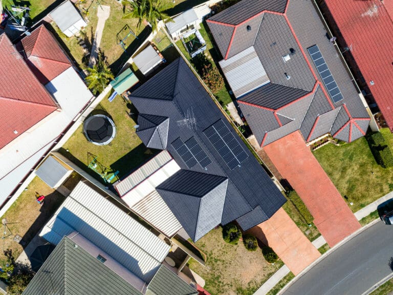 An aerial view of a house with solar panels on the roof.