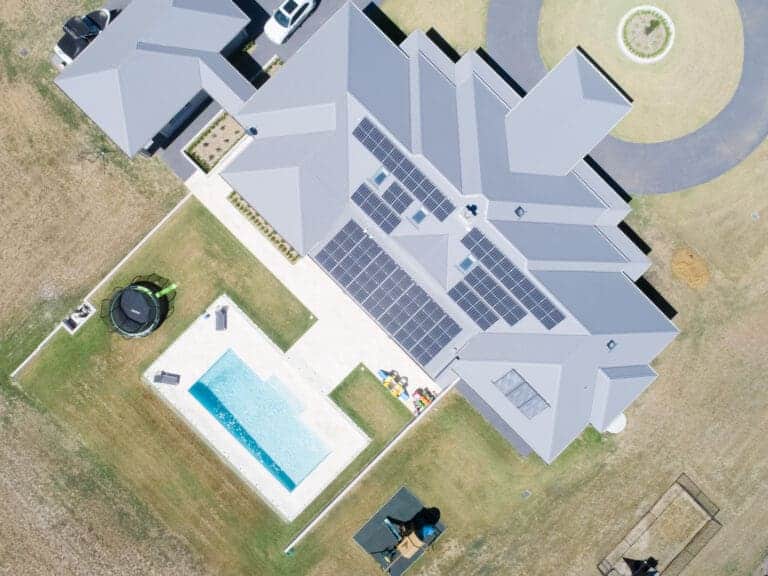 An aerial view of a house with solar panels on the roof.