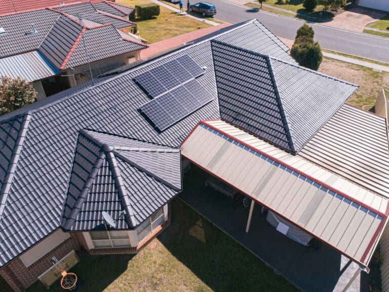 An aerial view of a house with solar panels on the roof.