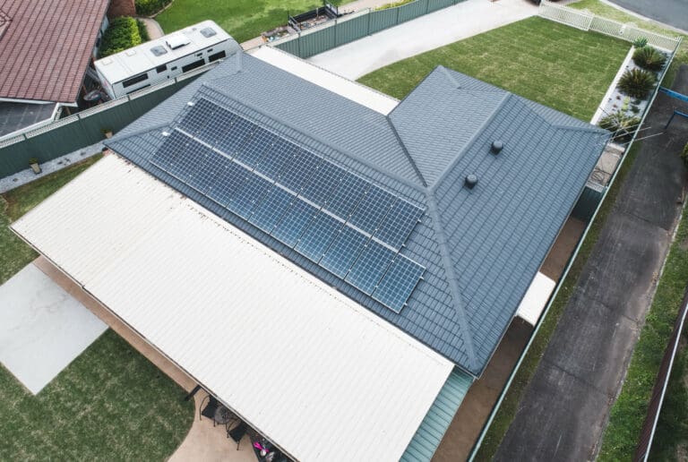 An aerial view of a house with solar panels on the roof.