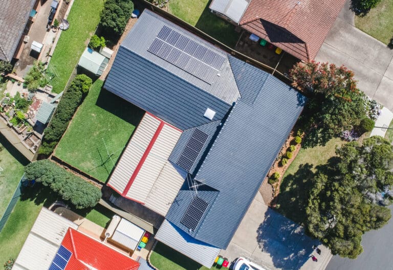 An aerial view of a house with solar panels on the roof.