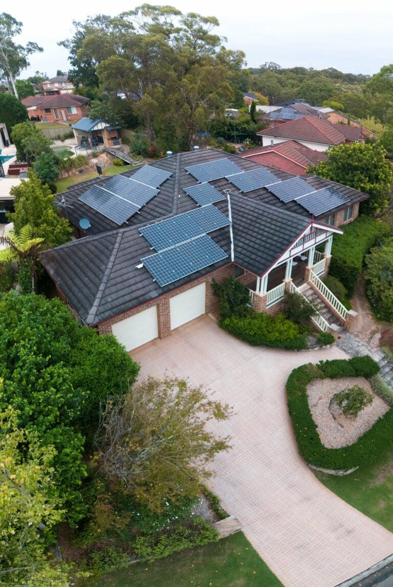 An aerial view of a home with solar panels on the roof.
