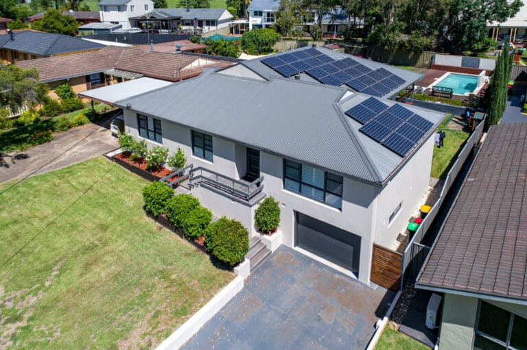 An aerial view of a house with solar panels on the roof.