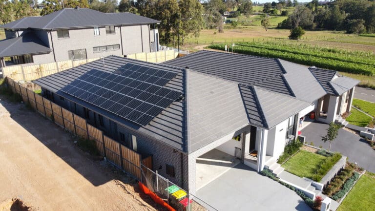 An aerial view of a house with solar panels on the roof.