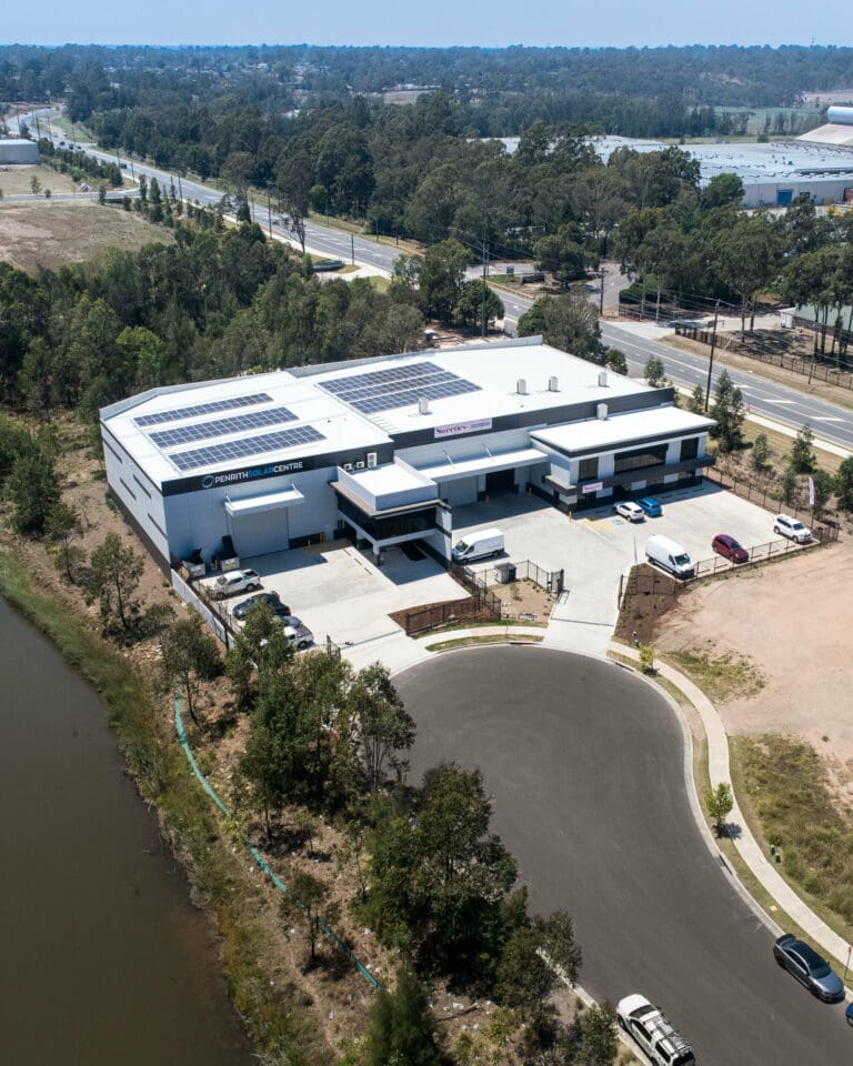 An aerial view of a building with solar panels on the roof.