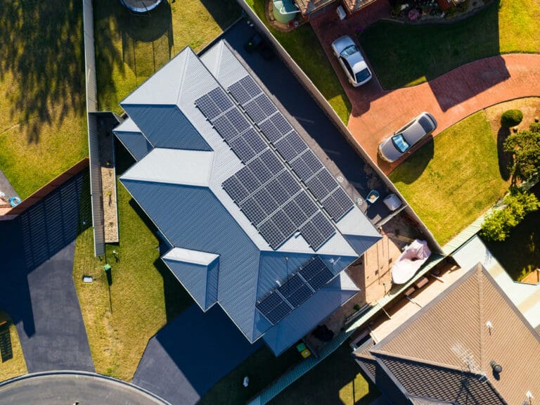 An aerial view of a house with solar panels on the roof.