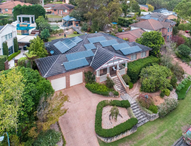 An aerial view of a home with solar panels on the roof.