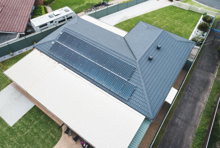 An aerial view of a house with solar panels on the roof.