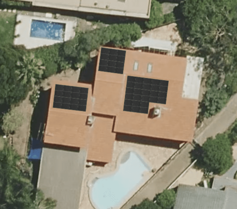 An aerial view of a house with solar panels on the roof.