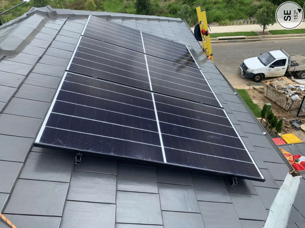 A solar panel on a Terracotta slate roof of a house.